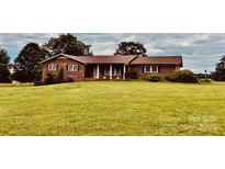 Well-maintained brick house with a sprawling front yard and a welcoming covered entryway at 6714 Old Shelby Rd, Vale, NC 28168