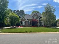 Charming two-story home with brick and stone, manicured lawn and colorful landscaping in a desirable neighborhood at 7018 Dowington Dr, Charlotte, NC 28277