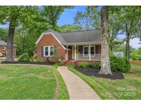 Charming brick home with a welcoming front porch and well-manicured landscaping at 725 W Graham St, Shelby, NC 28150