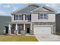 Two-story home showcasing stone accents, vertical siding, gray shingles and a two-car garage at 7909 Old Brook Rd, Sherrills Ford, NC 28673