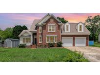 Charming brick two-story home with manicured lawn and an attached two-car garage at 8429 Meadowcroft Ct, Charlotte, NC 28215