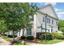 Charming townhome with light yellow siding, manicured landscaping, and beautiful mature trees at 939 White Point Dr, Huntersville, NC 28078