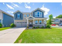 Charming two-story home featuring a welcoming front porch and a well-manicured lawn at 1004 Earlston Rd, Indian Trail, NC 28079
