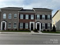 Charming townhomes featuring brick exteriors, black shutters, and well-maintained landscaping at 110 W Pine St, Lincolnton, NC 28092