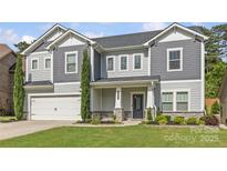 Charming two-story home featuring a well-manicured lawn, gray siding and stone accents for curb appeal at 11209 Flenniken Ct, Charlotte, NC 28277