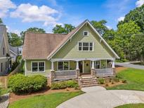 Charming two-story home with stone accents, inviting front porch, and a well-manicured lawn at 1500 Lynway Dr, Charlotte, NC 28203