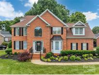 Charming two-story brick home with black shutters, landscaped front yard, and a welcoming entrance at 15737 Agincourt Dr, Huntersville, NC 28078