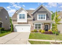 Charming two-story home with a manicured lawn, lovely landscaping, and a two-car garage at 1659 Loggerhead Dr, Lancaster, SC 29720