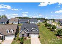 Charming home with stone accents, a manicured lawn, and an attached two car garage at 19004 Dry Narrows Way, Charlotte, NC 28278