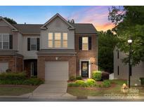 Charming brick-front townhome with a one-car garage and beautifully landscaped front yard at 4278 Park South Station Blvd, Charlotte, NC 28210