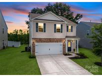 Inviting two-story home featuring a brick-accented facade and a well-maintained lawn at 461 Misty Law Ln, Clover, SC 29710