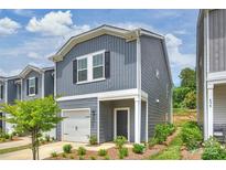 New construction home featuring gray siding, covered entry, attached garage, and landscaped front yard at 502 Tayberry Ln, Fort Mill, SC 29715