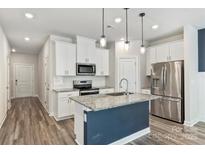 Modern kitchen with granite countertops, stainless steel appliances, and a center island at 502 Tayberry Ln, Fort Mill, SC 29715