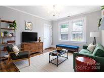 Cozy living room featuring hardwood floors, a modern chandelier, and comfortable seating at 524 Hawthorne Ln, Charlotte, NC 28204