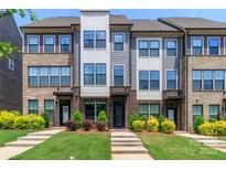 Beautiful townhome exterior featuring brick accents, modern siding, lush landscaping, and a well-manicured lawn at 628 Uwharrie River Rd, Charlotte, NC 28211