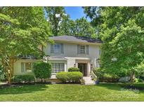 Charming painted brick home with a well-manicured lawn and lush landscaping at 6409 Ilex Ct, Charlotte, NC 28211