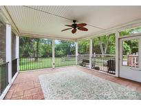 Inviting screened porch with ceiling fan, stone flooring, and view of the expansive backyard at 6908 Lancer Dr, Charlotte, NC 28226