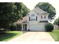 Charming two-story home featuring attached two-car garage, well-maintained lawn, and mature trees at 7830 Shiny Meadow Ln, Charlotte, NC 28215