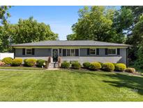 Charming single-story home featuring a well-manicured front yard, inviting entrance, and gray brick exterior at 7921 Willhill Rd, Mint Hill, NC 28227