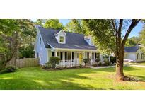 Charming home featuring light blue siding, a welcoming porch with a yellow door, and a well-maintained front yard at 8742 Rittenhouse Cir, Charlotte, NC 28270
