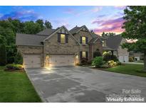 Beautiful brick home featuring a three-car garage, lush landscaping, and a well-manicured lawn at 10620 Euclid Nw Ave, Concord, NC 28027