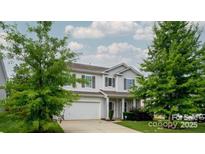 Charming two-story home with attached garage and well-maintained landscaping, set against a bright, cloudy sky at 11109 Pond Valley Ct, Charlotte, NC 28269