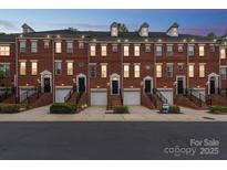 Charming brick townhomes with individual garages, front stairs, and well-maintained landscaping create inviting curb appeal at 1126 Dean Hall Ln, Matthews, NC 28105