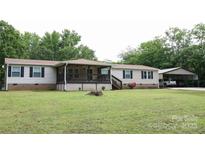 Charming ranch-style home with a covered front porch and carport provides ample parking and curb appeal at 1184 Sherwood Rd, Clover, SC 29710