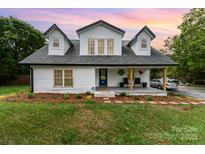 Charming two-story farmhouse with a welcoming front porch and manicured lawn at 12504 Culp Rd, Gold Hill, NC 28071