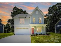 Charming two-story home with a light gray exterior, a red front door, and an attached garage at 1645 Carolina Cir, Gastonia, NC 28054