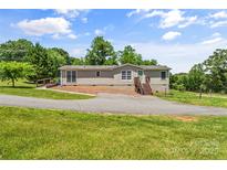 Charming single-story home with light siding, manicured lawn, and inviting curb appeal on a sunny day at 1730 Woodbend Ln, Conover, NC 28613
