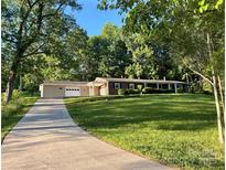 Charming single-story home with a lush front lawn and long driveway leading to an attached garage at 2130 Vashti Rd, Taylorsville, NC 28681