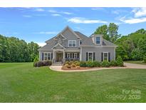 Charming two-story home with manicured lawn, decorative landscaping, and a welcoming entryway at 224 Hidden Meadows Dr, Mooresville, NC 28117