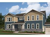 Two-story home featuring stone accents, beige and blue siding, multi-pane windows, and professionally landscaped yard at 2529 Mabel Ln, Monroe, NC 28110