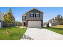Two story home featuring gray siding and stone accents, a two-car garage, and a well-manicured lawn at 3064 Ora Smith Rd, Lincolnton, NC 28092