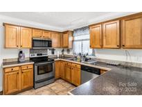 Well-lit kitchen with wood cabinetry, stainless steel appliances, and a neutral countertop at 4285 Palmer Lloyd Rd, Lancaster, SC 29720
