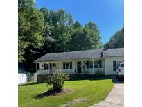 Charming ranch-style home with a covered porch and a well-manicured lawn surrounded by lush trees at 4337 Gelinda Ct, Gastonia, NC 28056