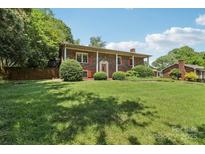 Charming brick home with red shutters and well-manicured lawn and shrubbery at 5626 Sandhurst Rd, Hickory, NC 28602