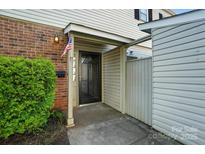Inviting entryway with brick accents and a charming American flag waving by the front door at 5947 Quail Hollow Rd # A, Charlotte, NC 28210