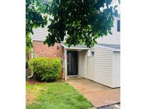 Charming townhome entrance featuring brick accents, a covered entryway, and well-maintained landscaping at 5947 Quail Hollow Rd # A, Charlotte, NC 28210