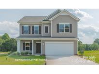 Charming two-story home with neutral siding, black shutters, and a two-car garage at 6328 Busch Way, Midland, NC 28107