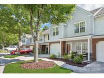 Charming townhouse featuring a brick facade, well-kept landscaping, and an inviting entryway with seating at 8108 Christmas Ct, Charlotte, NC 28216