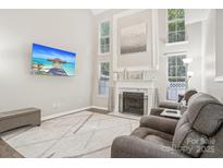 Inviting living room with a cozy fireplace, ample natural light, and comfortable seating at 8108 Christmas Ct, Charlotte, NC 28216