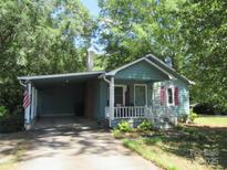 Charming home featuring a covered carport, inviting front porch, and lush landscaping at 1051 S Brady Ave, Newton, NC 28658