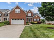 Charming two-story brick home with an attached garage and well-manicured lawn at 108 Planters Dr, Statesville, NC 28677