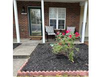 Inviting brick front porch with charming seating area and well-maintained landscaping at 11218 Grass Field Rd # 1083, Charlotte, NC 28213