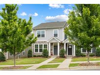 Charming gray two-story townhome featuring stone accents, a manicured lawn, and inviting curb appeal at 1201 Township Pkwy, Belmont, NC 28012