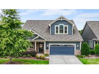 Charming two-story home boasts a blue exterior, well-manicured landscaping, and a two-car garage at 1284 Independence St, Fort Mill, SC 29708