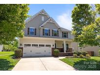 Charming two-story home with a manicured lawn, two-car garage, and inviting front porch at 1300 Yellow Springs Dr, Indian Land, SC 29707