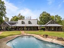 Inviting home exterior featuring a pool and lush greenery, perfect for outdoor relaxation and entertaining at 1433 Kern Carlton Rd, Salisbury, NC 28146